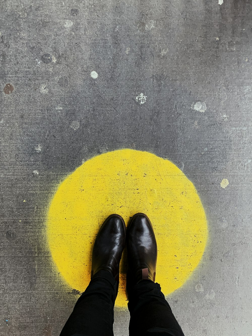 Persona de pie sobre una superficie redonda pintada de amarillo