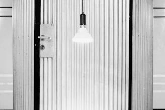 Close-up of a matte black Stilex steel security door with brushed steel accents under soft lighting.