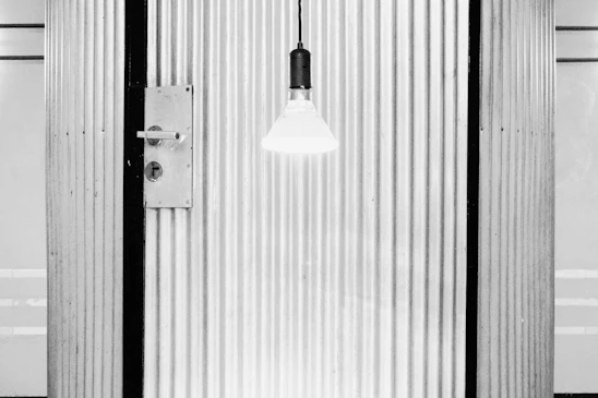 Close-up of a matte black Stilex steel security door with brushed steel accents under soft lighting.