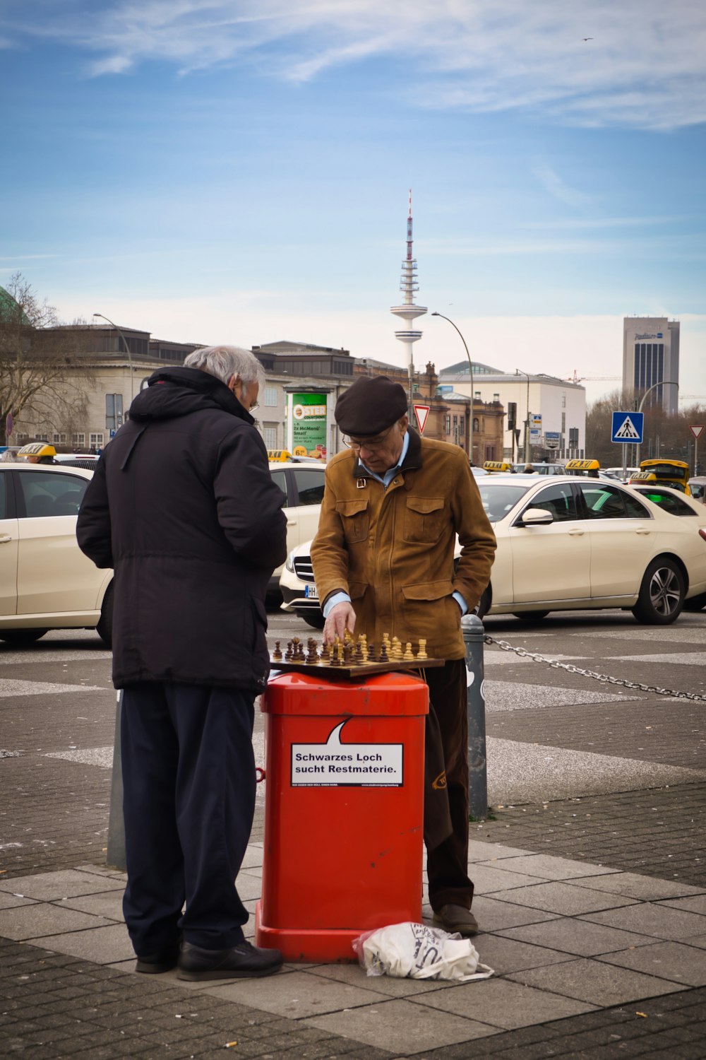 two men standing while playing chess