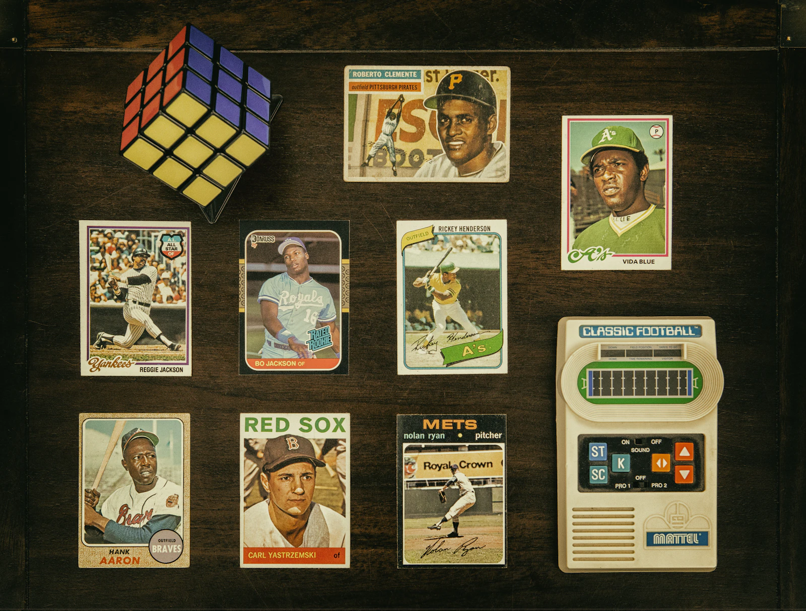 Assorted raw baseball cards laid on dark wood as intake evidence before submission