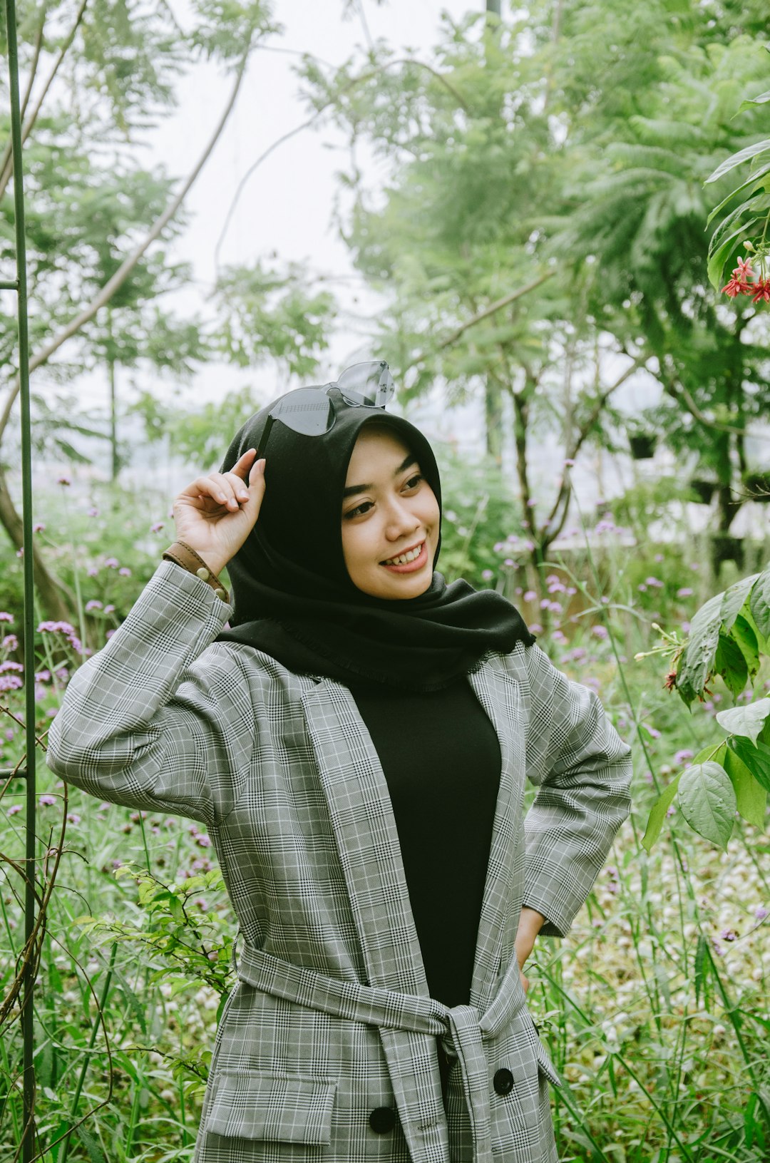 smiling woman wearing grey coat with black hijab