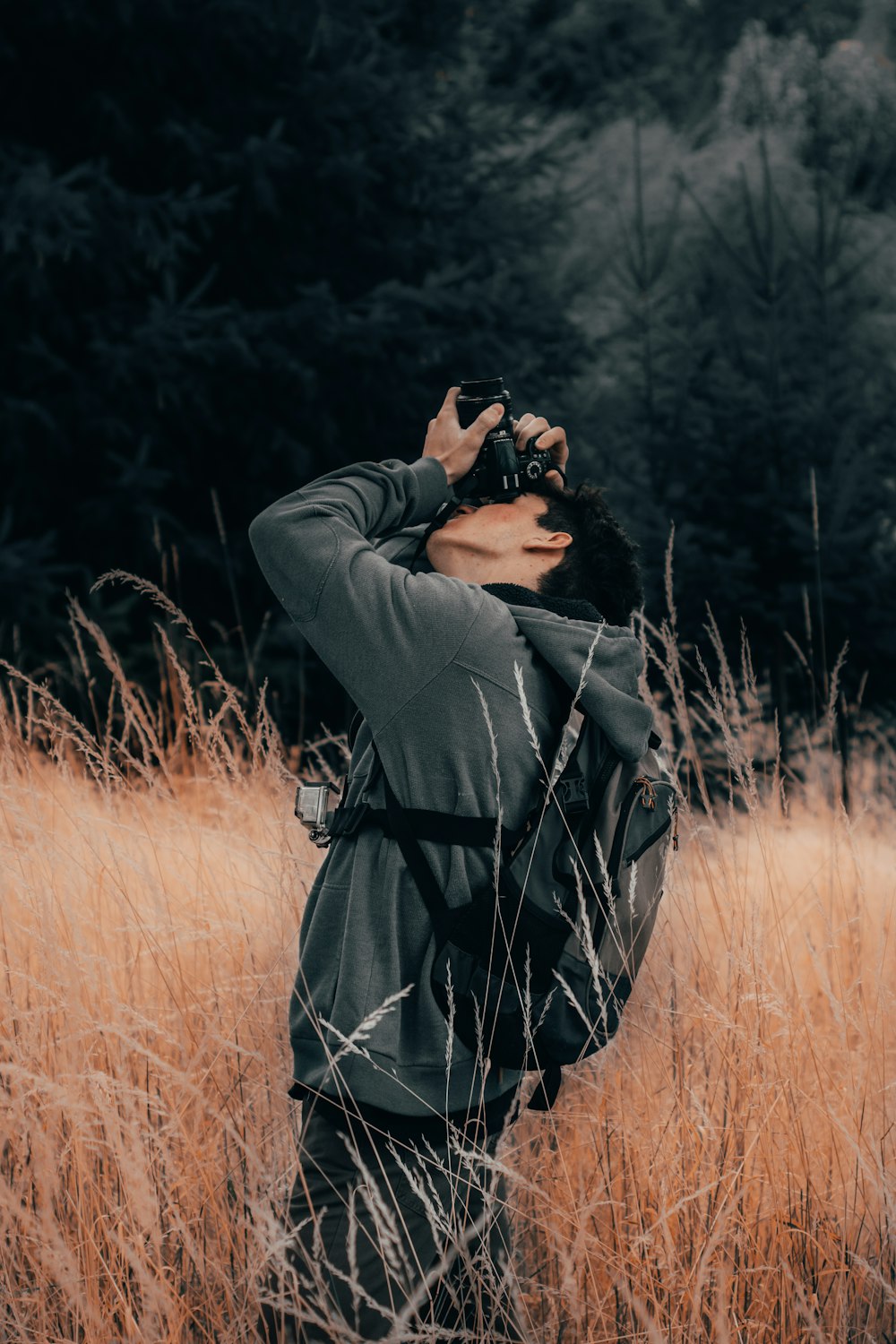 man taking photo using DSLR camera outdoor