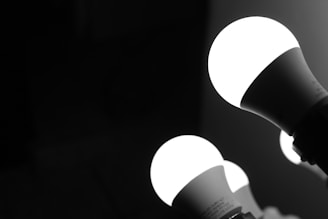 Three illuminated LED light bulbs against a dark background, with a focus on the brightness and contrast between the light bulbs and their surroundings.
