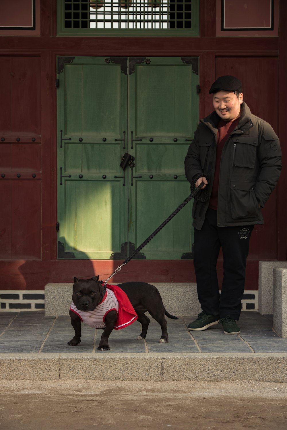 man holding black dog leash