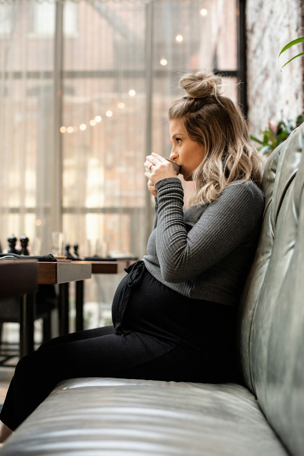 pregnant woman zipping on cup sitting on sofa
