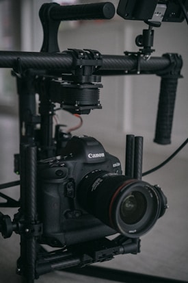 A professional camera mounted on a stabilizing rig, featuring a prominent lens and visible controls. The setup appears robust and designed for high-quality photography or videography.