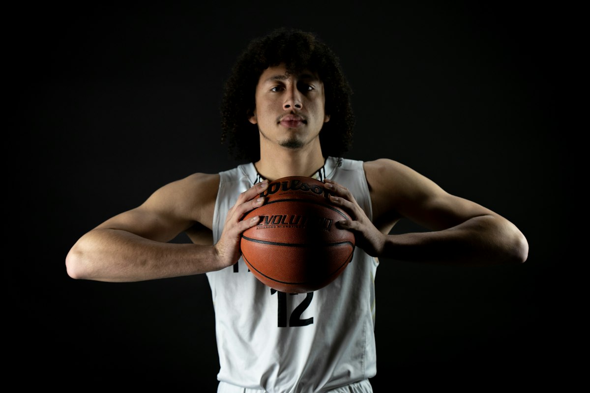 Young basketball player in a white jersey holding a ball with both hands