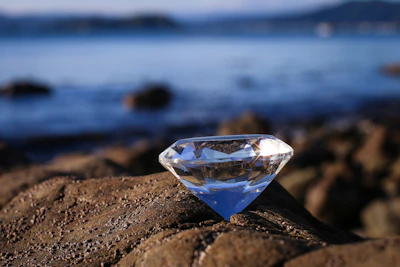 Close-up of a radiant natural diamond resting on a deep blue ocean background.
