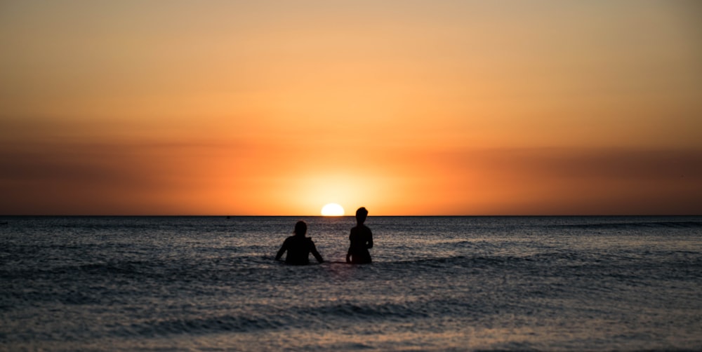 two people on sea during sunset