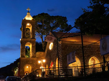 A nighttime shot of a church illuminated softly, with digital bell sounds resonating through the neighborhood.