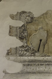 Close-up of hands carefully restoring an old fresco on a historic wall.