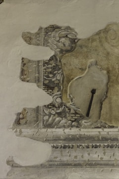 Close-up of hands carefully restoring a damaged fresco.