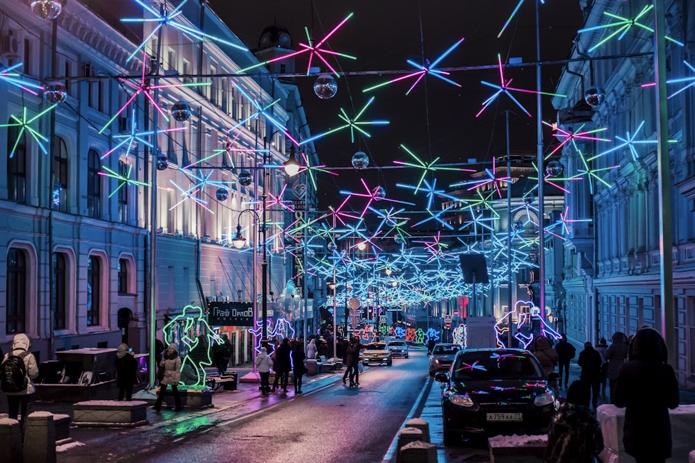 a group of people walking down a city street at night