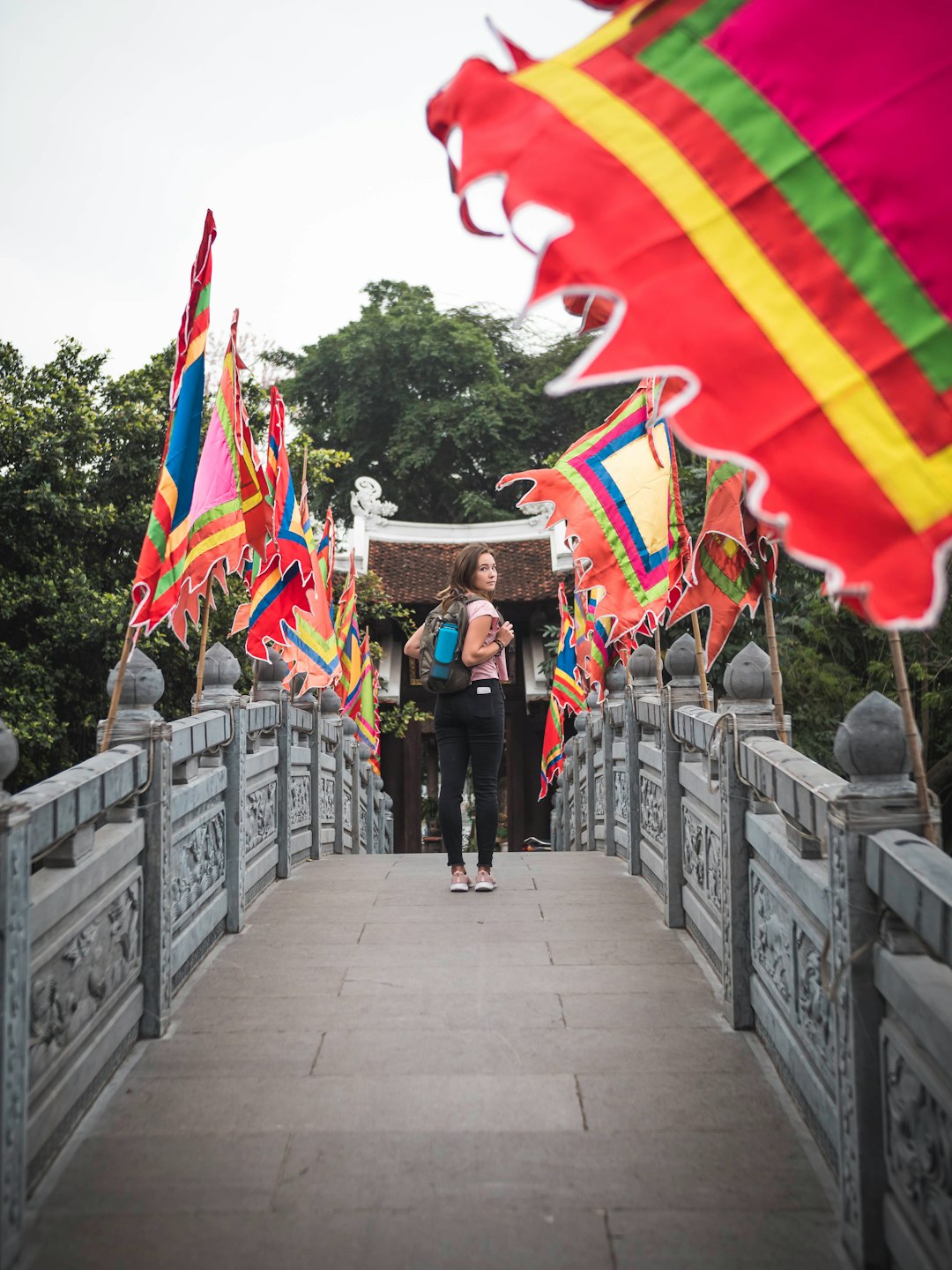 woman standing bridge near flags