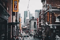 A city street with various small businesses and pedestrian activity.