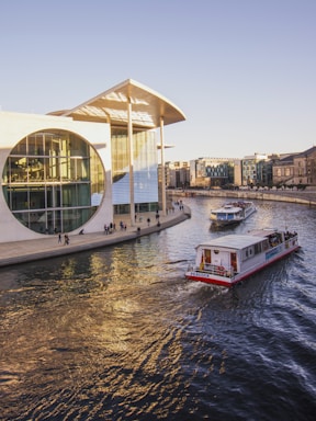 white and red boat near buildings