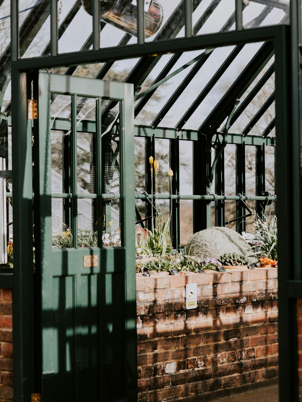 green wooden door near brick wall