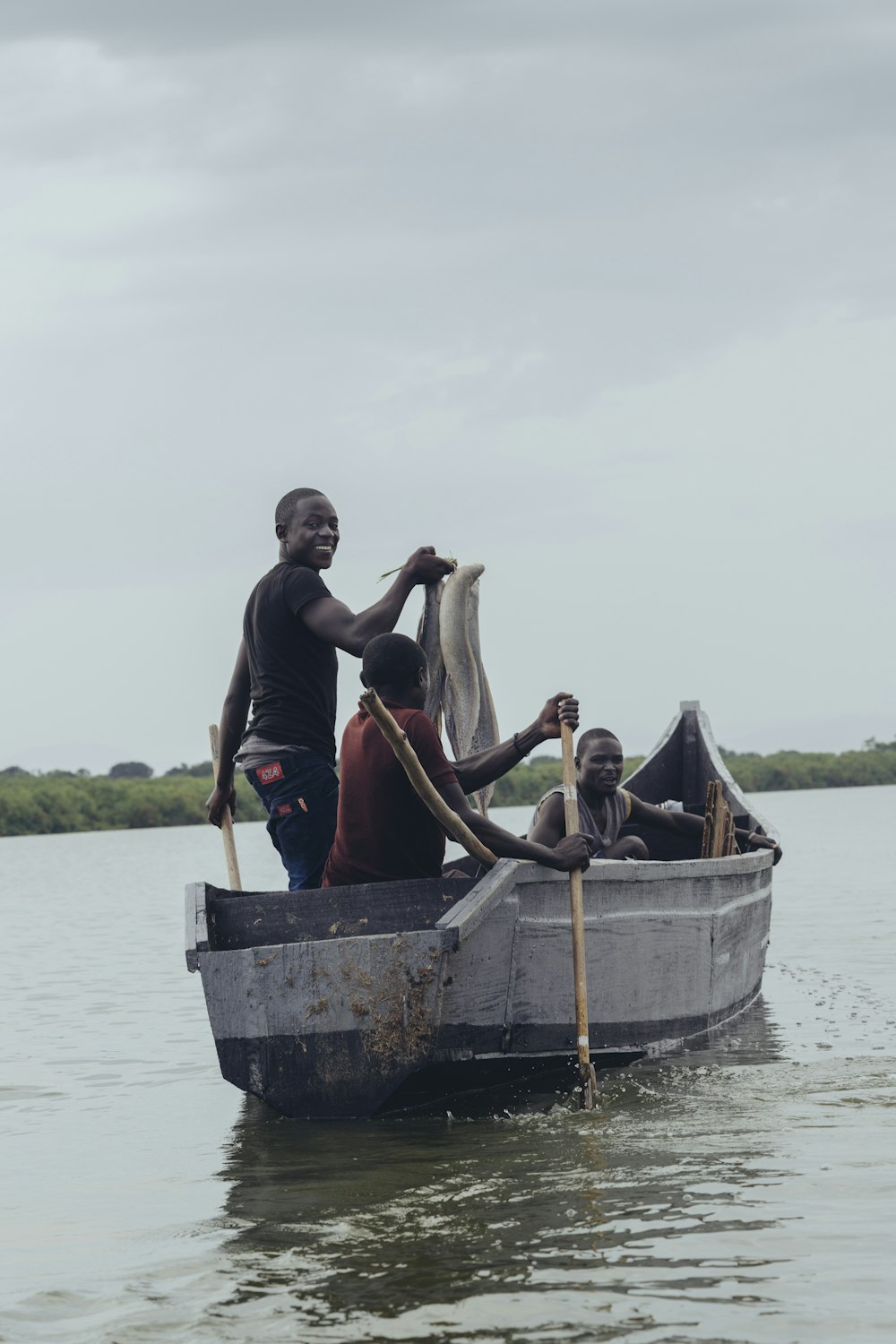 bateau gris avec trois hommes sur la photographie de mise au point