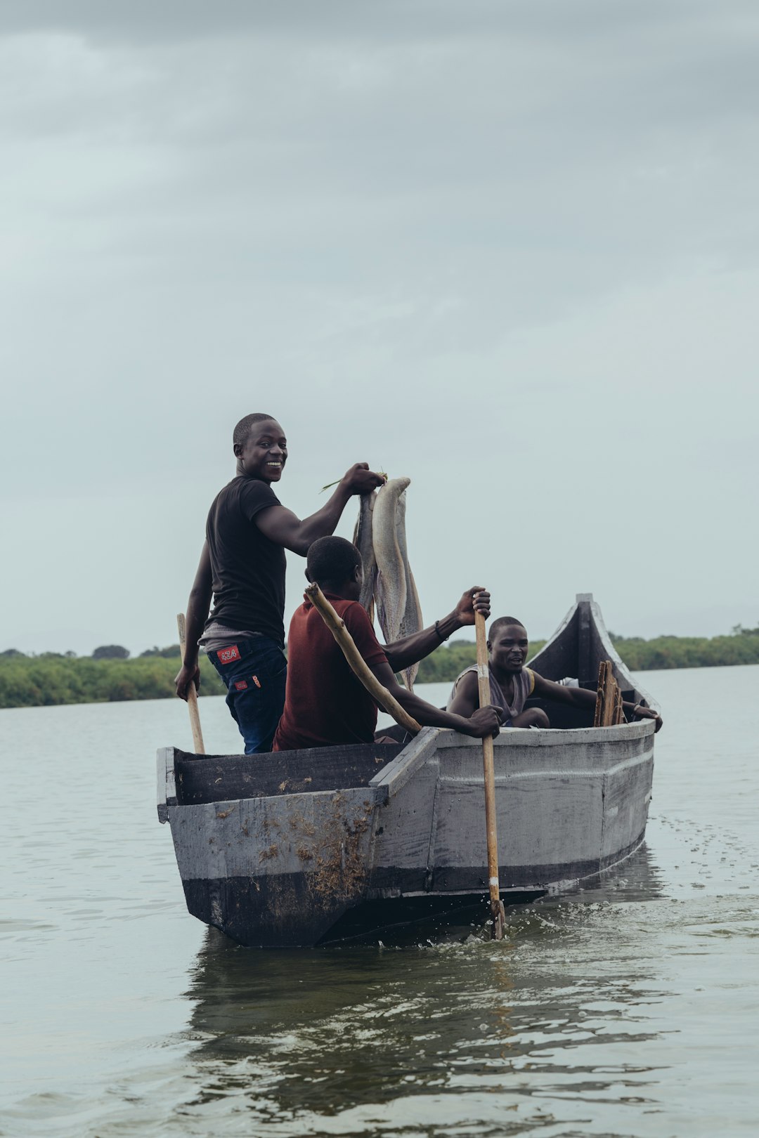 gray boat with three man on focus photography