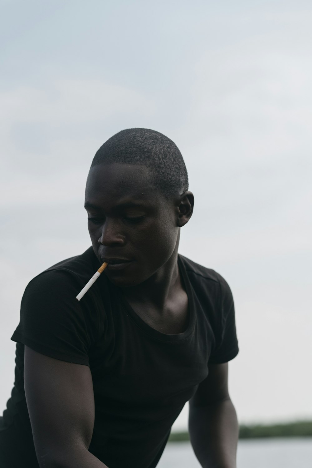 man smoking under white clouds