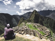 rule of thirds photography of man sitting on rock formation