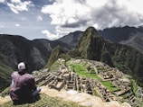 rule of thirds photography of man sitting on rock formation