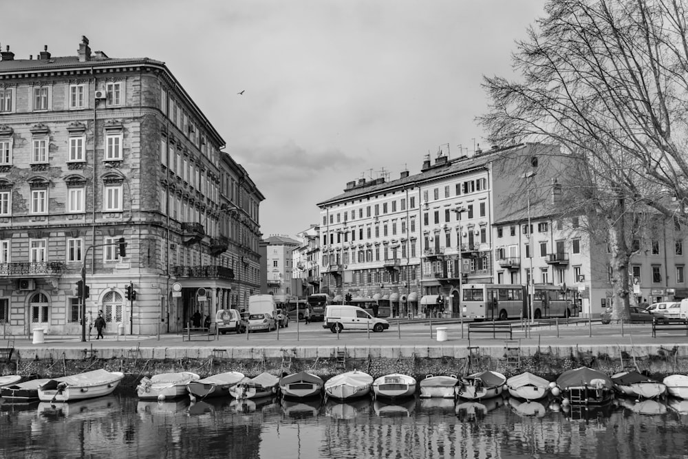 grayscale photo of buildings and boats