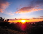 Sunset over a vibrant residential area with walking paths and streetlights glowing.