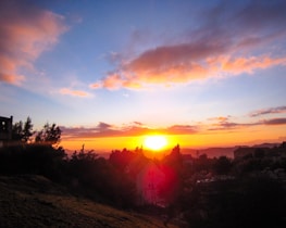 Sunset over a vibrant residential area with walking paths and streetlights glowing.