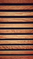 Vertical wooden slats of mixed hardwoods forming a contemporary cladding design.