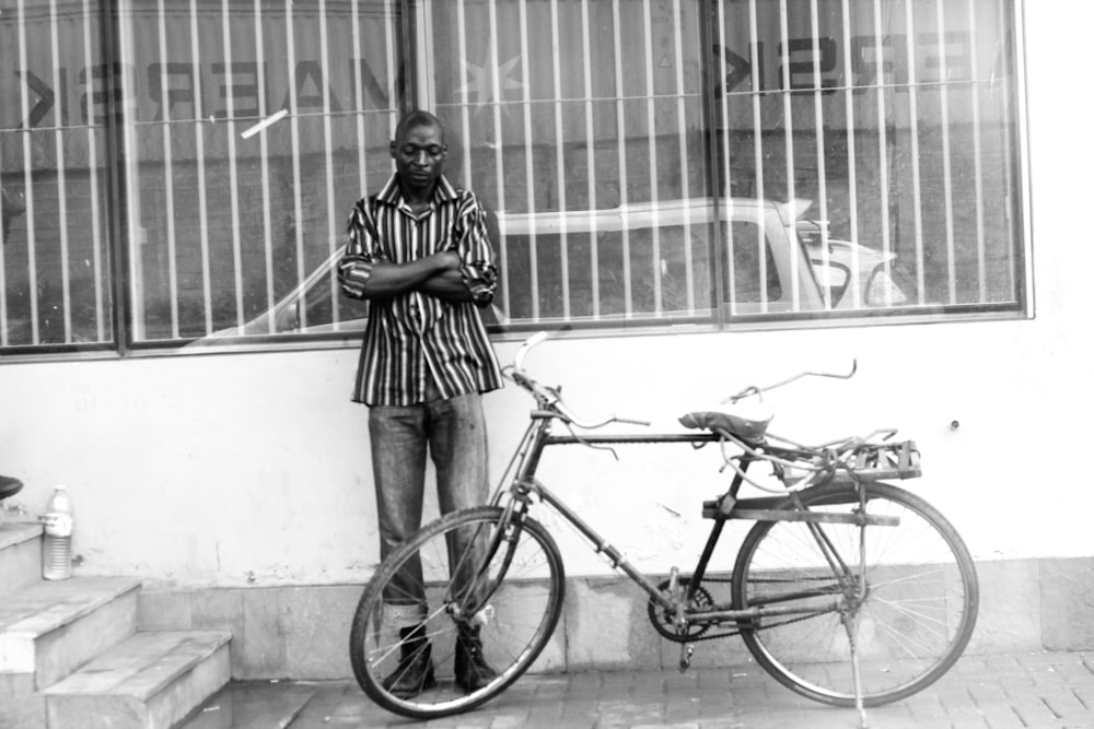 man standing beside gray commuter bike