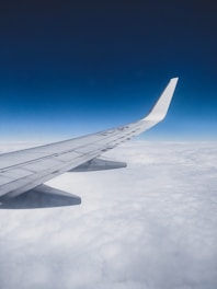 close-up photography of white plane wing on sky