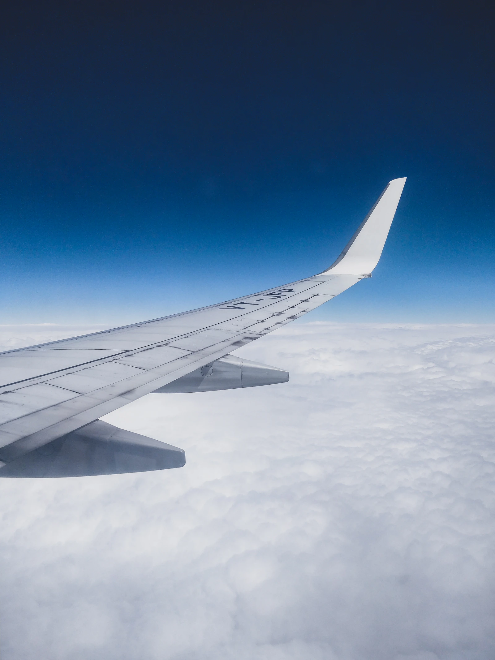 Ala de un avión sobre un mar de nubes bajo el cielo azul