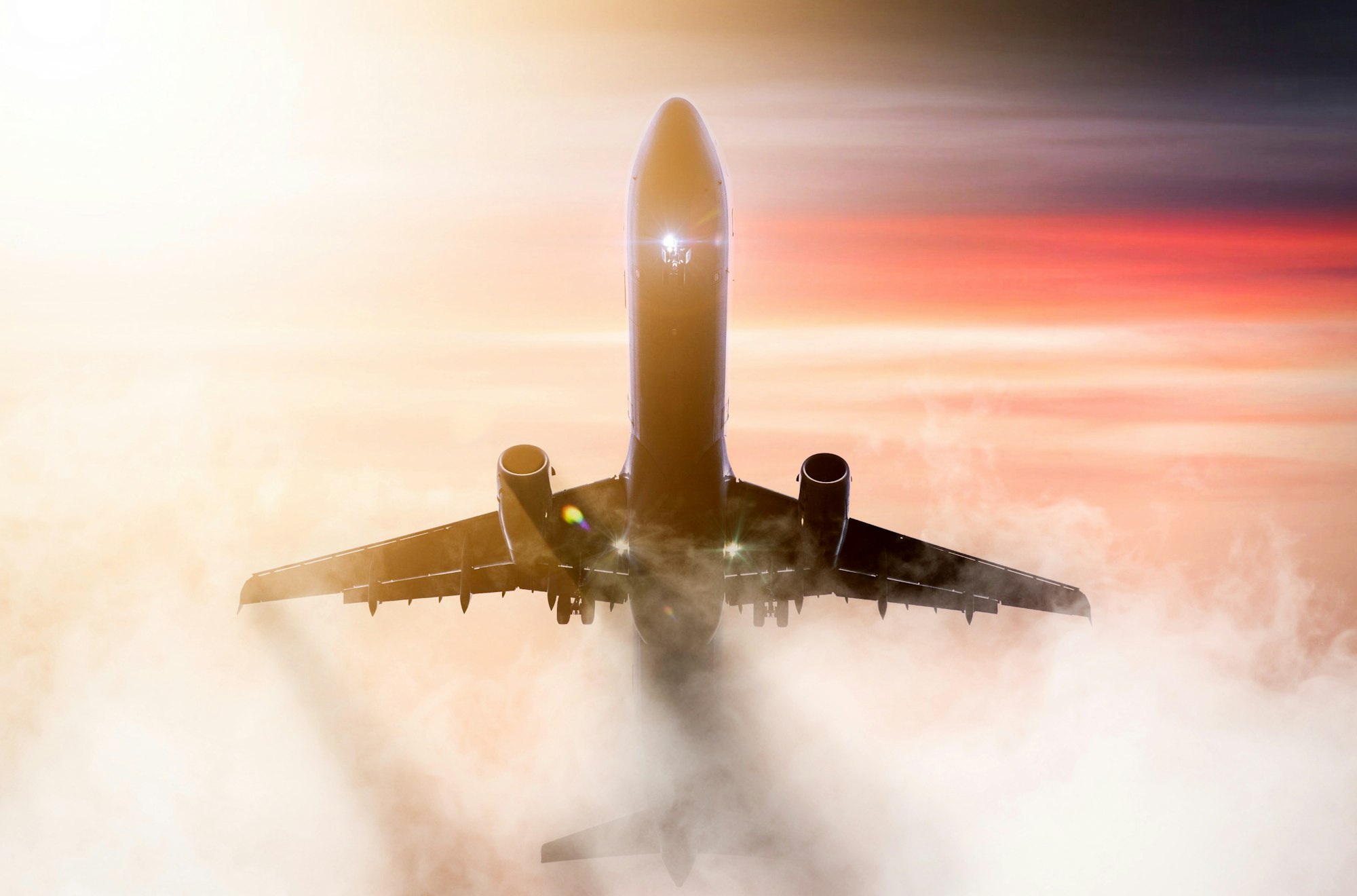 a plane taking off through the clouds