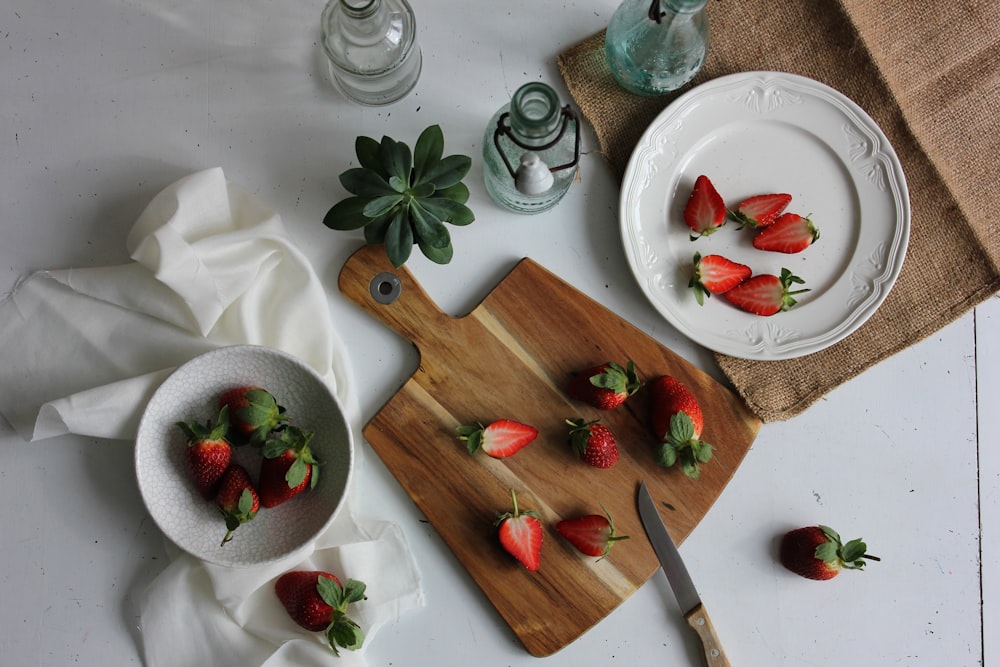 fresas en rodajas en plato y tabla de cortar