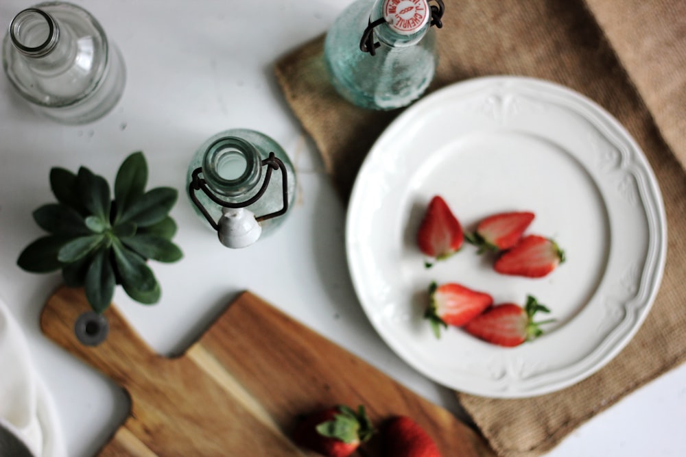 fruits on plate with bottles on white table