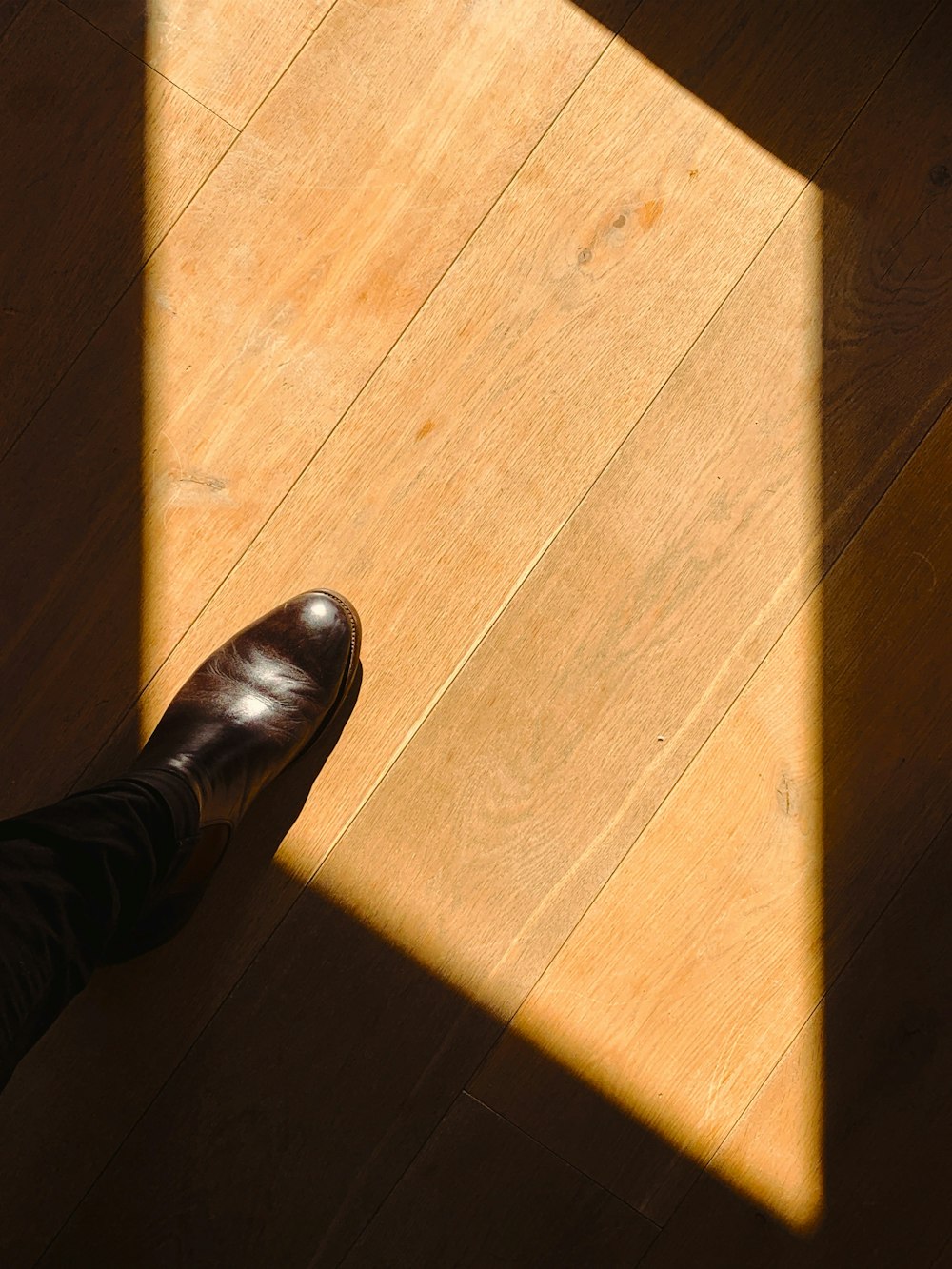 pessoa em pé no chão de madeira marrom