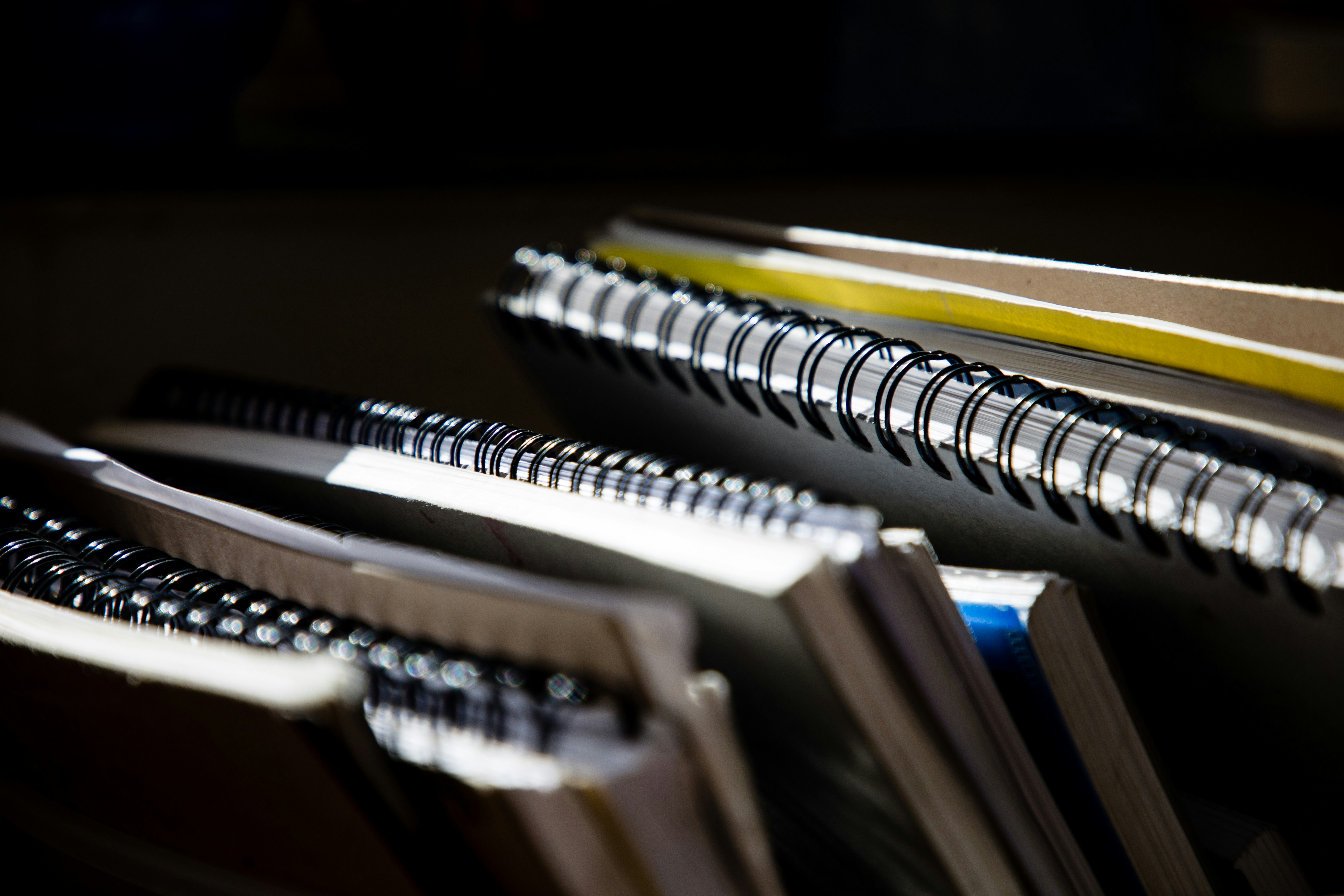 photograph of several spiral notebooks and paperback workbooks