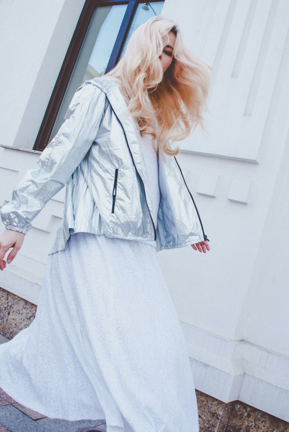 woman walking beside white building