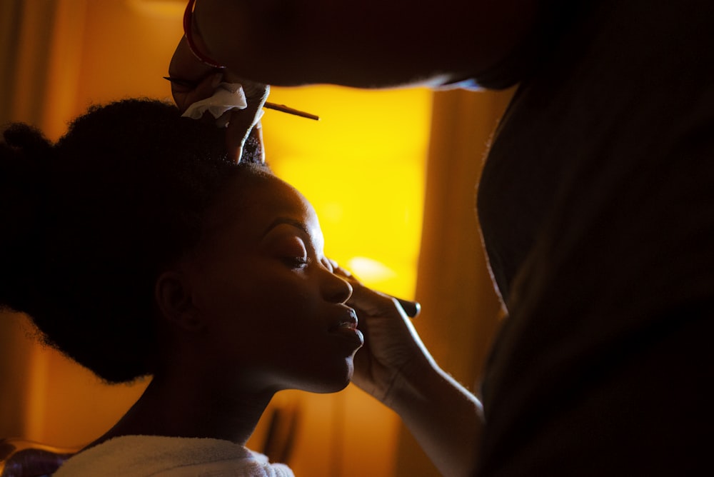 person putting make up on woman