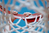 A close-up of a basketball spinning on a player's fingertip against a blue sky.