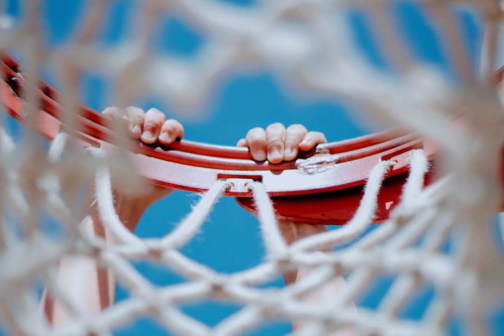 person hanging on red basketball hoop