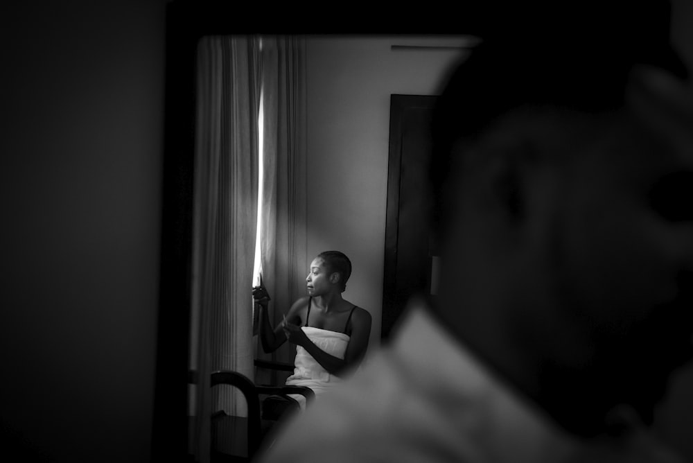 grayscale photography of woman sitting indoor