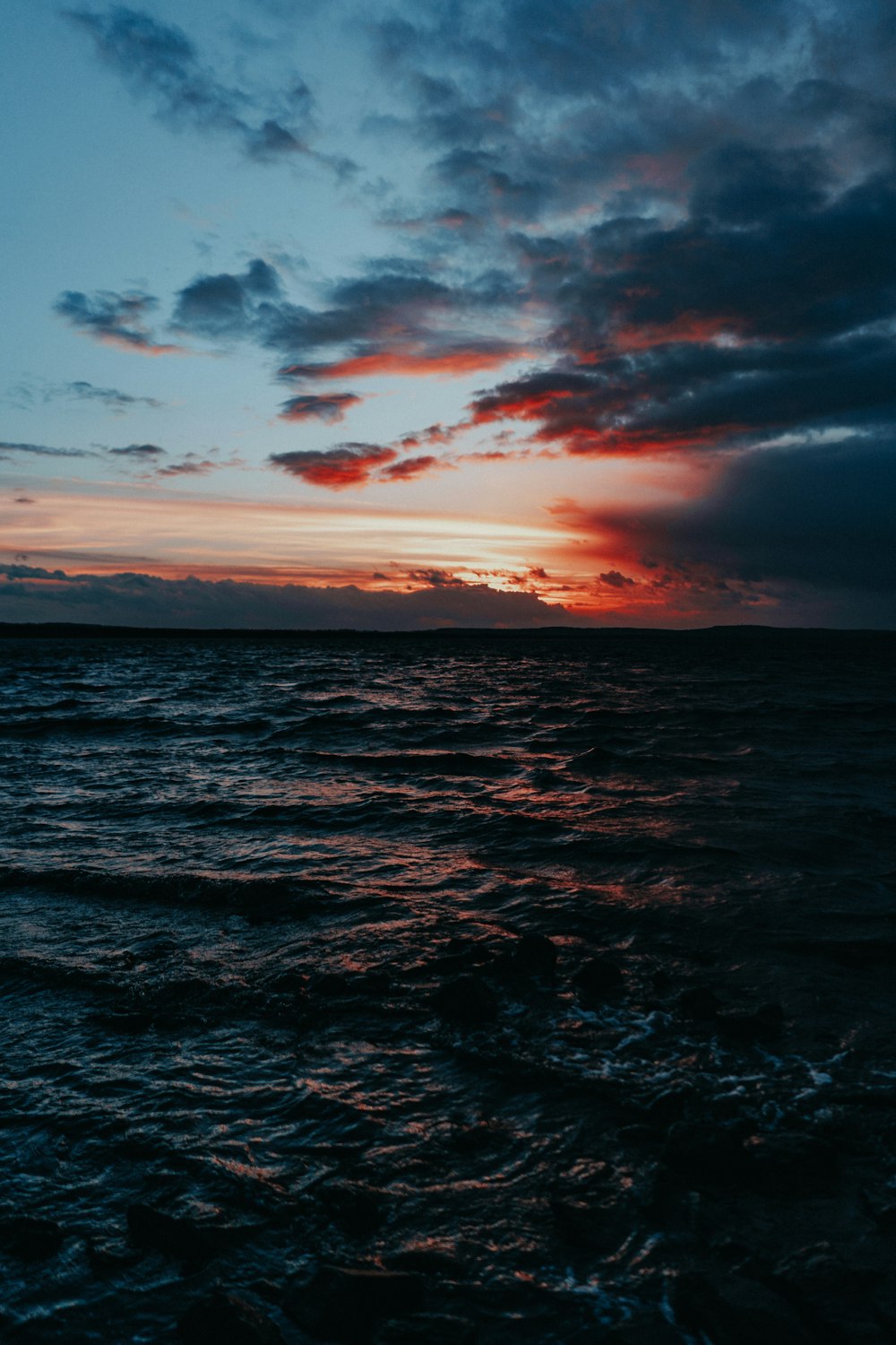 body of water under grey sky