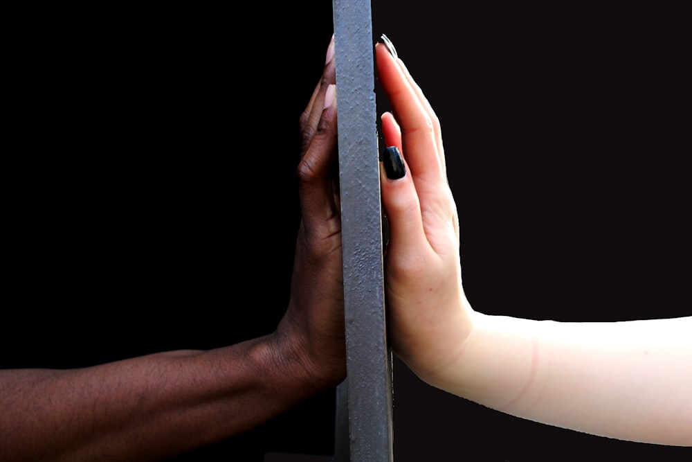 two person touching black surface