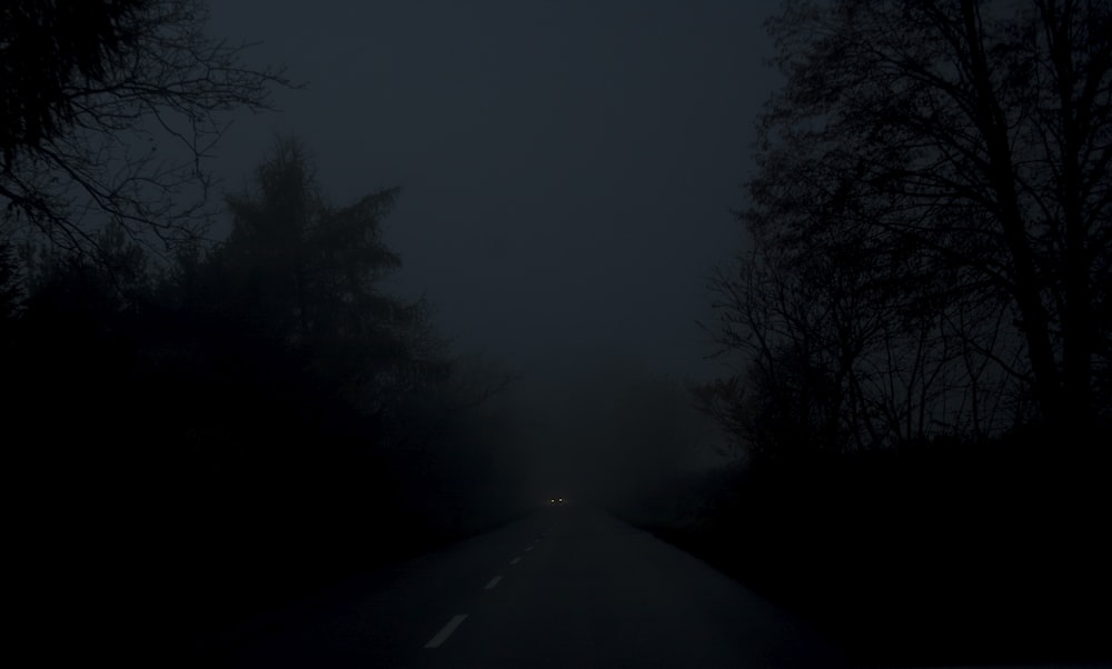 a car driving down a dark road at night