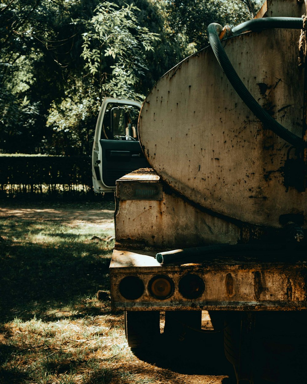 an old truck parked in a field with trees in the background