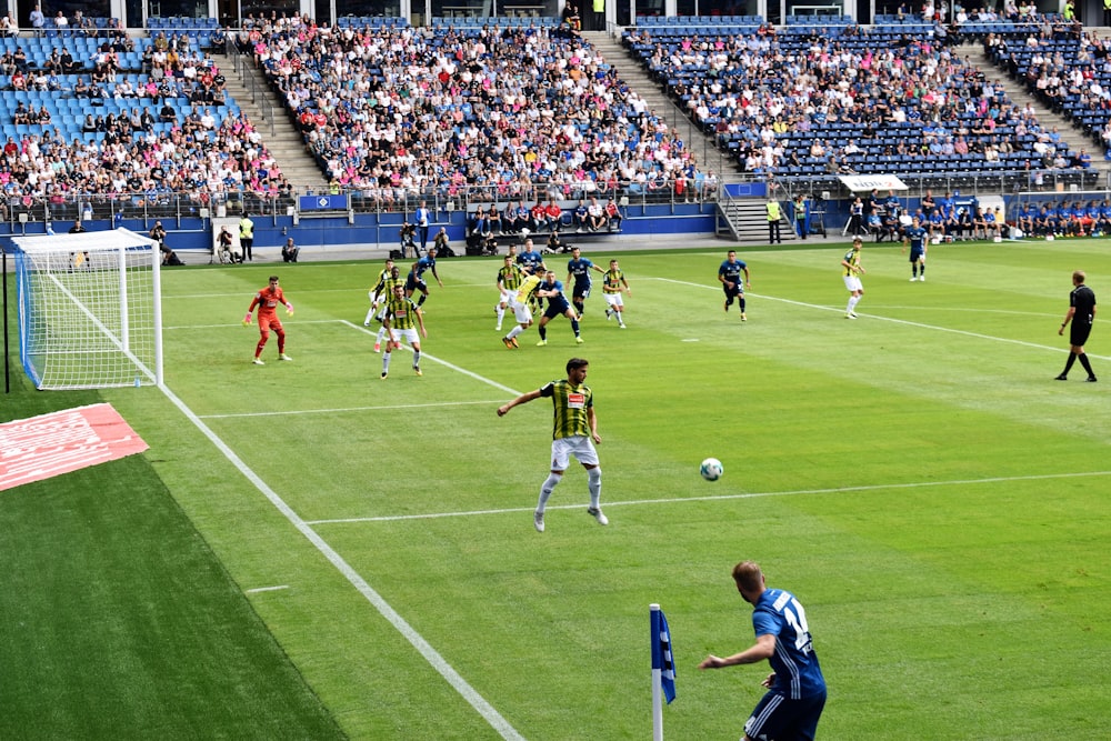 Männer, die tagsüber Fußball auf dem Fußballplatz spielen