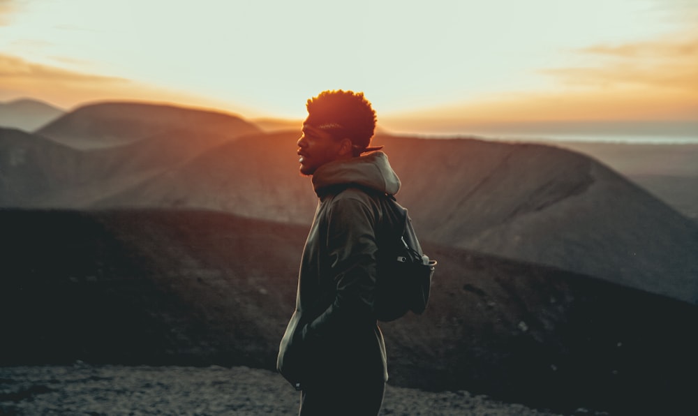 Hombre de pie junto a la cordillera durante el día